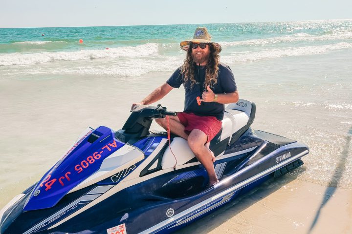 a man sitting on a jet ski on the beach