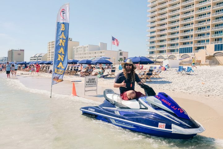 a man sitting on a jet ski on the beach
