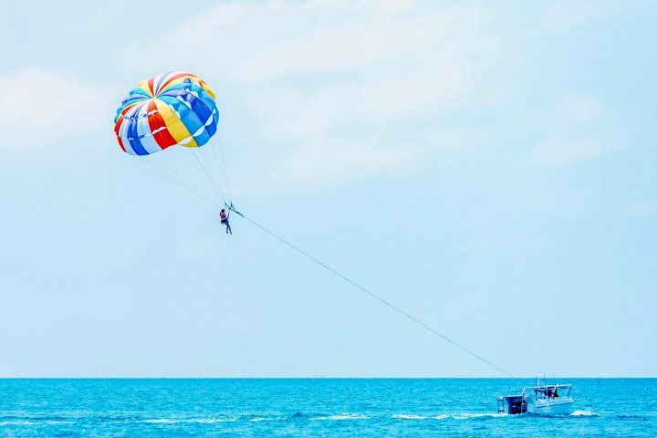 a person parasailing over a body of water